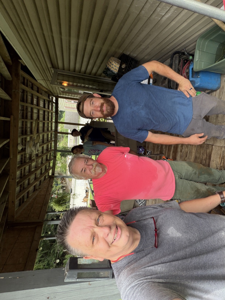 Pastor Jim with two members of the mission team on the porch they came to rebuild.